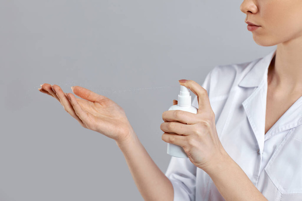 woman doctor in white uniform using sanitizer dispenser - Foto, Bild