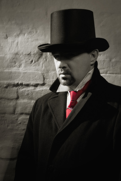 άνθρωπος στο κορυφαίο καπέλο μαύρο παλτό, και σε μια κόκκινη γραβάτα - Φωτογραφία, εικόνα