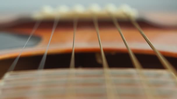 Detalle de primer plano de cuerdas de guitarra de acero y trastes para hacer música. Cuello de guitarra en enfoque selectivo
. - Metraje, vídeo