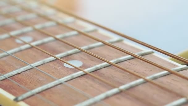 bruine houten akoestische gitaar en een deel van de nek en snaren close-up macro selectieve focus - Video