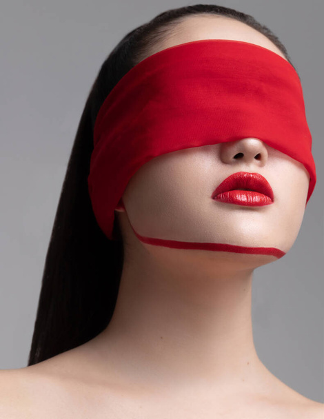Epidemic Fear COVID-19I move around the world.I am scared too.Don`t plunge into the medieval darkness.I am ready to fight.Don`t turn a blind eye to our common problem.Gerl Asia. Blindfold. Red scarf. Blindfold girl. girl with eyes closed - Foto, Imagen