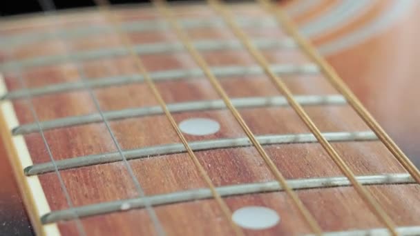 gitaarsnaren en frets voor het maken van muziek. Selectieve focus op één gitaardrempel. - Video