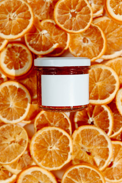 Bank of moisturizing thick cream for face and body on a background of dried oranges. Organic handmade vitamin C product for anti-age effect. - Photo, Image