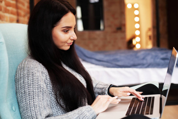Женщина остается дома и работает над ноутбуком онлайн
 - Фото, изображение