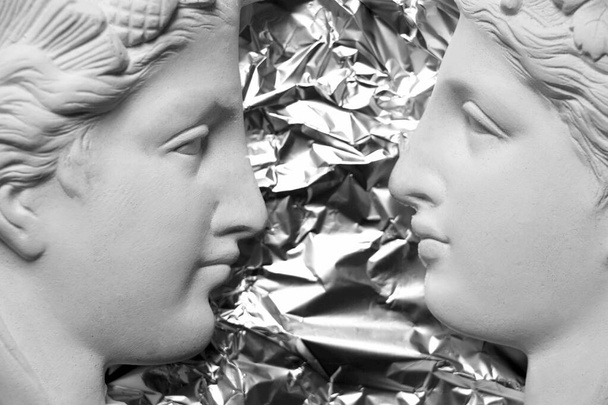 due facce di una statua di gesso di profilo su uno sfondo isolato
 - Foto, immagini