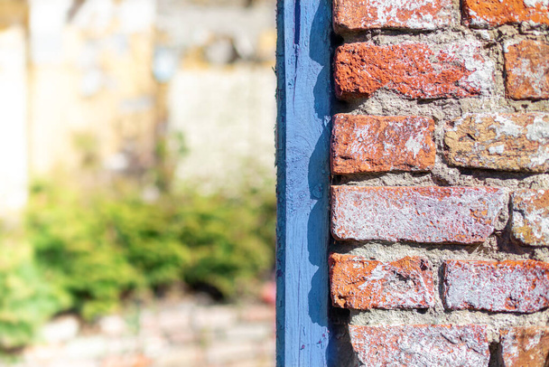 Background from a fragment of a wall with a blue frame. Red brick. Blue board. Blurry background. - Photo, Image