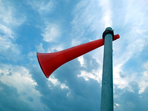 un lazo de cuerno de plástico rojo con un tubo de plástico blanco con fondo de cielo azul
 - Foto, Imagen