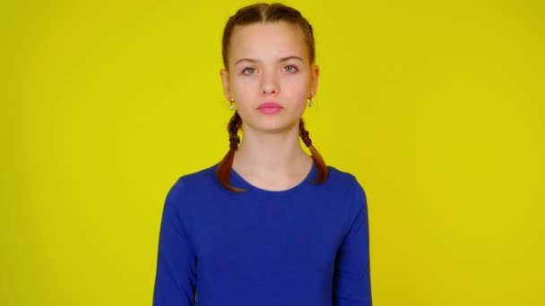 Teenage girl in blue pullover makes a gesture with two hands - Metraje, vídeo