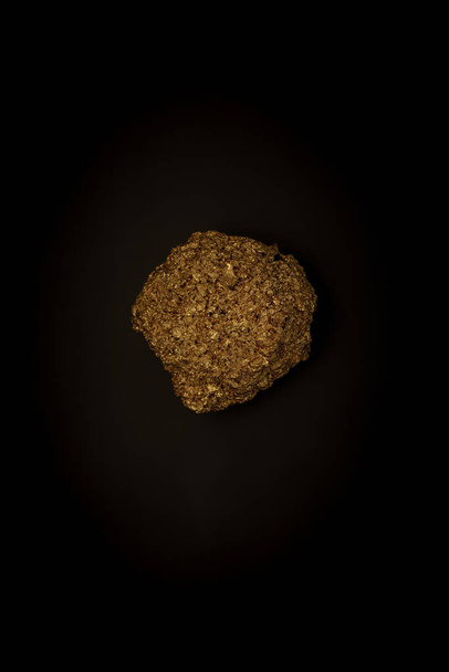 Golden stone on a black background, stylish minimalistic composition with copyspace - Fotoğraf, Görsel