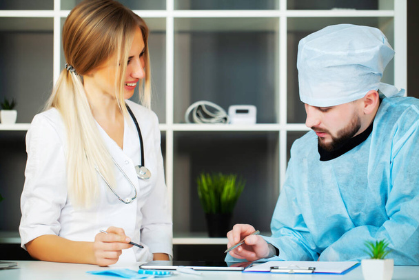 Doctor at the clinic examines the patient and provides advice - Foto, Imagem