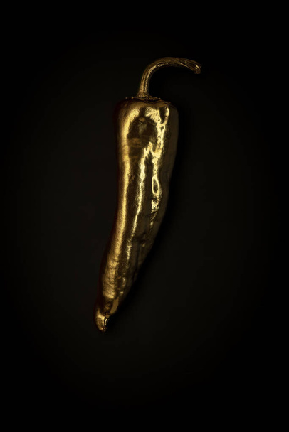 Golden pepper on a black background, stylish minimalistic composition with copyspace - Fotoğraf, Görsel