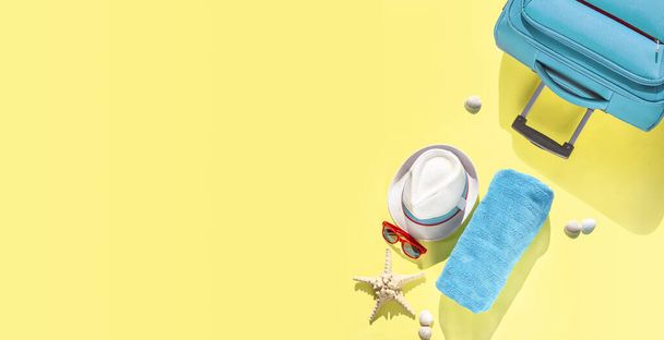 Conjunto de accesorios de viaje sobre fondo amarillo. Sombrero de playa, maleta, gafas de sol, toalla, estrellas de mar, conchas para las vacaciones de verano de las mujeres. Concepto de moda de banner, vista superior, plano
 - Foto, imagen