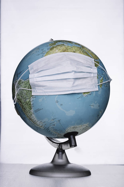 Земной шар с хирургической маской Концепция чрезвычайной ситуации со здоровьем, Ковид-19 или коронавирус, пандемия
 - Фото, изображение