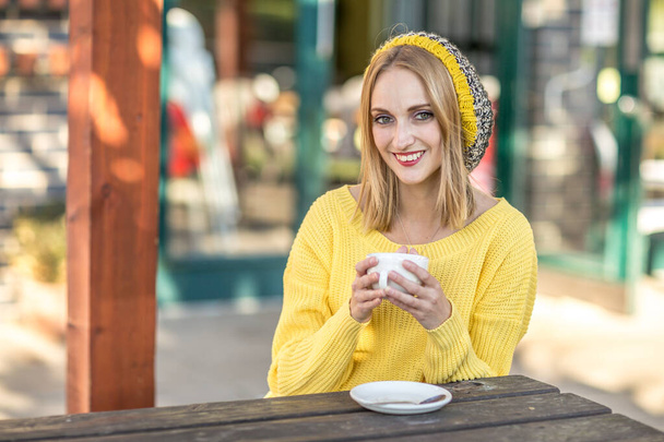 Νεαρή γυναίκα απολαμβάνει τον καφέ της - Φωτογραφία, εικόνα