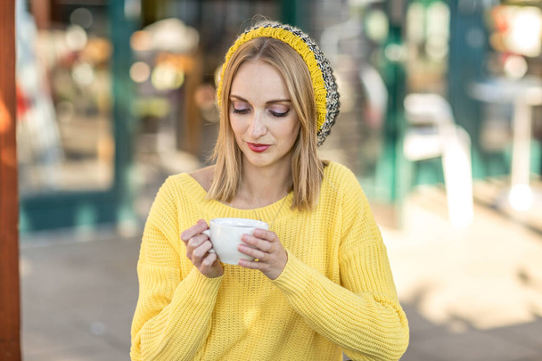 a young woman enjoying a coffee - Foto, afbeelding