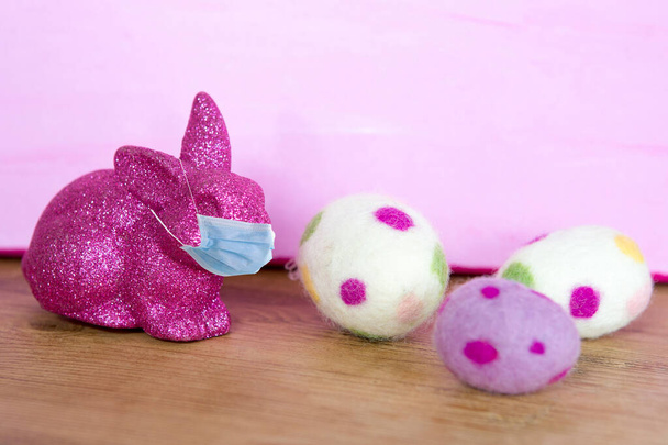 fialový zajíček v masce respirátoru a s velikonočními vejci  - Fotografie, Obrázek