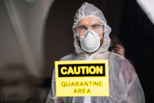 Hombre con mono blanco protector, máscara y gafas en la cara. Coronavirus, pandemia, covid-19, gripe y concepto de cuarentena
. - Foto, imagen