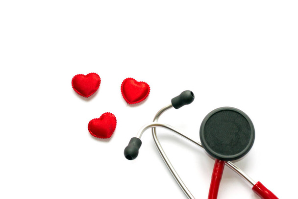 Diagnosis and treatment in cardiology. Medicine concept - Close up red stethoscope and hearts isolated on white background. Copy space for text. - Photo, Image