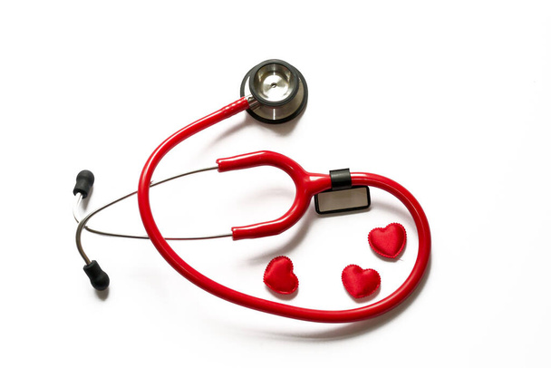 Diagnóza a léčba v kardiologii. Medicína koncept - zblízka červená stetoskop s názvem nálepka a srdce izolované na bílém pozadí. Kopírovat prostor pro text. - Fotografie, Obrázek
