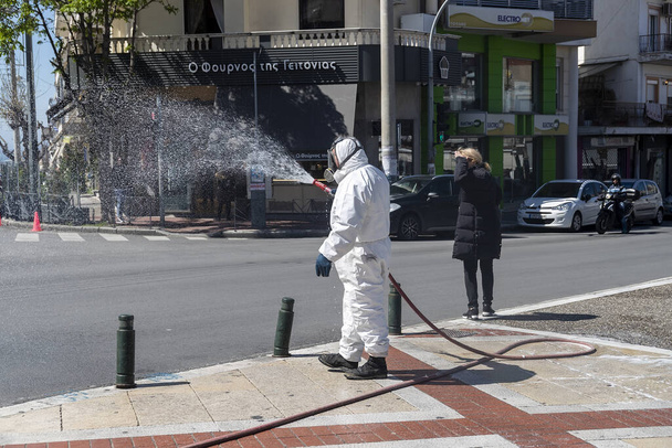 Thessaloniki, Greece - April 8, 2020: Workers sprays disinfectant as part of preventive measures against the spread of the COVID-19, the novel coronavirus, in a streets and squares - Φωτογραφία, εικόνα