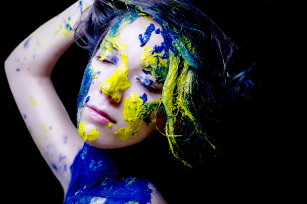 Schönheit Mode Porträt einer Frau bemalt blau und gelb auf schwarzem Hintergrund - Foto, Bild
