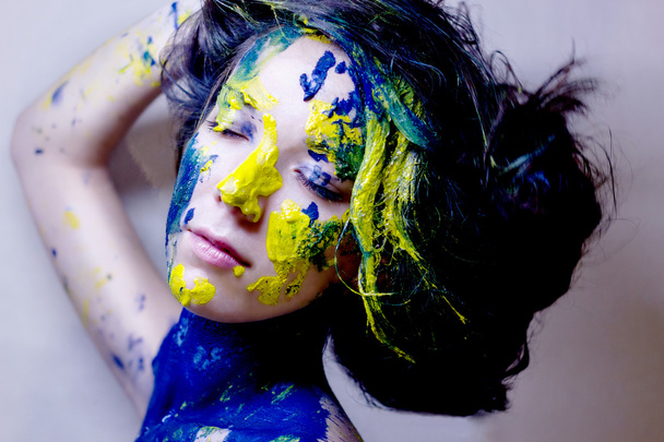 krása módní portrét ženy namalovaný modré a žluté na černém pozadí - Fotografie, Obrázek