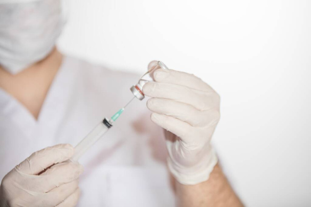 A health worker drawing vaccine in vial into syringe for COVID-19, measles, flu shots - Foto, imagen