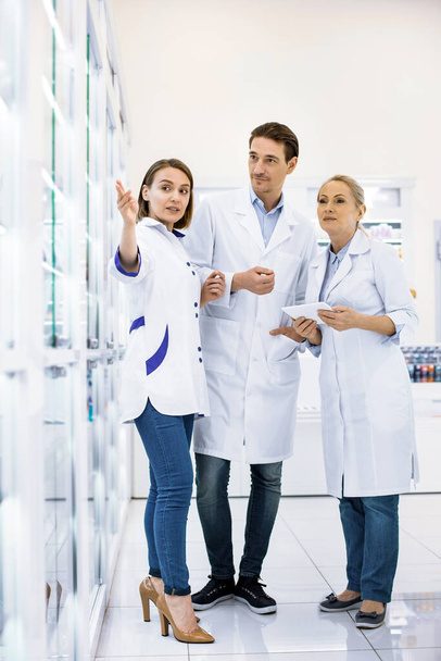 Three ambitious young pharmacists discussing new medication - 写真・画像