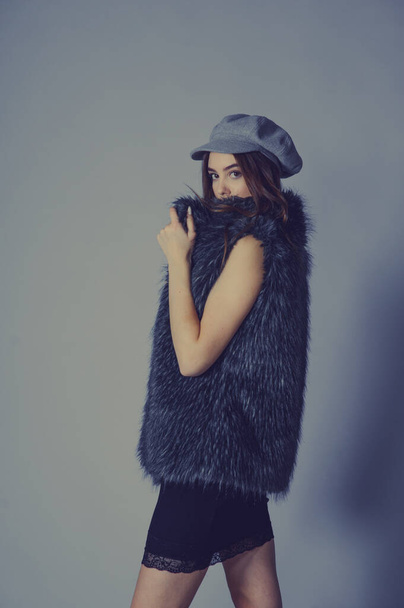 Portrait. magnificent portrait of a beautiful young woman. Perfect face beautiful girl portrait. brunette girl. Girl in a gray hat. little black dress. Girl in a vest with faux fur. Girl in a studio - Φωτογραφία, εικόνα
