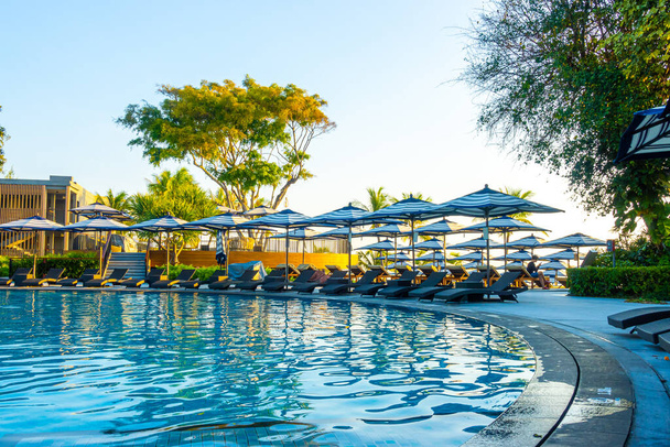 Парасолька і басейн ліжко навколо відкритого басейну в готельному курорті для подорожей концепція відпустки
 - Фото, зображення