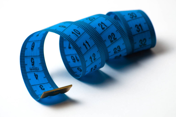 На белом фоне сантиметр. Концепция диеты и потери веса
 - Фото, изображение