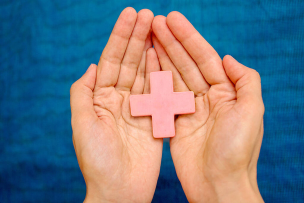 Pink cross on the palms of a young woman - Foto, imagen