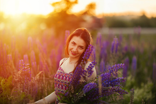 retrato al aire libre de una hermosa morena joven edad. atractiva chica sexy en un campo con flores
. - Foto, Imagen