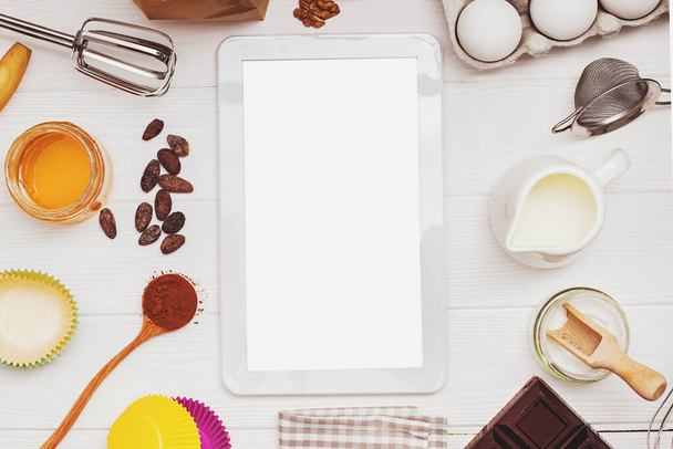 Ingredients and tools for baking and tablet with blank screen and place for text or image on white table - Foto, afbeelding