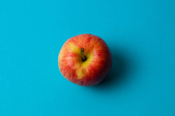 Jabłko na niebieskim tle. Zdrowe odżywianie, ilość kalorii i koncepcja odchudzania - Zdjęcie, obraz