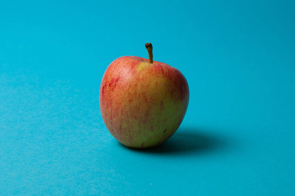 Яблоко на синем фоне. Здоровое питание, количество калорий и концепция потери веса
 - Фото, изображение