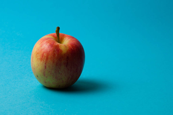 Manzana sobre fondo azul. Alimentación saludable, recuento de calorías y concepto de pérdida de peso
 - Foto, imagen