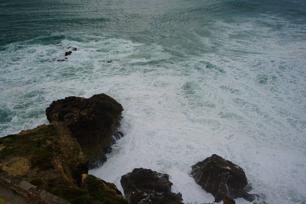 波がナザレの岩に押し入っています - 写真・画像