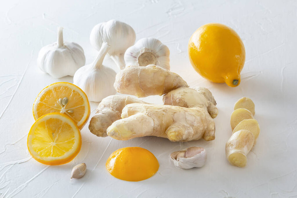 Ginger, garlic and lemon - a means to protect against viral infection and colds on a light wooden table. - Foto, Bild