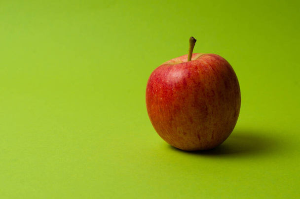 Apple on a green background. Healthy eating, calorie count and weight loss concept - Foto, imagen