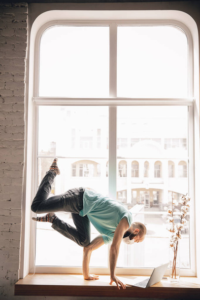 Jovem fazendo ioga em casa enquanto está de quarentena e trabalho freelance
 - Foto, Imagem