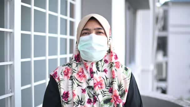 Coronavirus ve Hava kirliliği pm2.5 konsepti. Tıbbi maskeli genç, güzel Müslüman kadın, kameraya bakıyor. Sağlık ve tıbbi konsept. - Video, Çekim