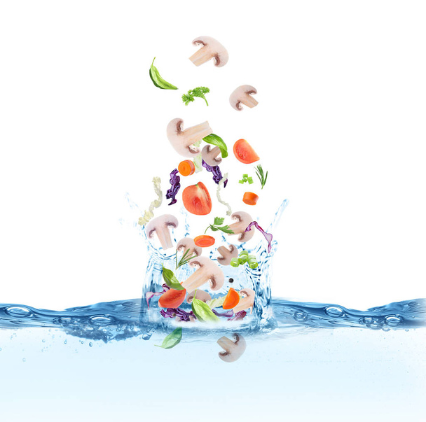Багато різних інгредієнтів потрапляють у воду з бризками. Рецепт супу
 - Фото, зображення