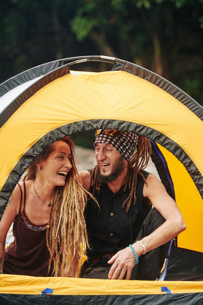 Iloinen tyylikäs kypsä pari rastat istuu teltassa ja nauttia retkeily viikonloppuna
 - Valokuva, kuva