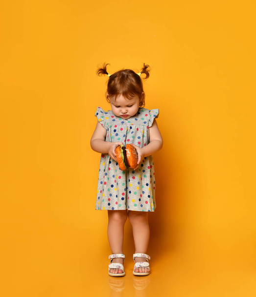 Little girl with hamburger in her hands. - Foto, Imagen