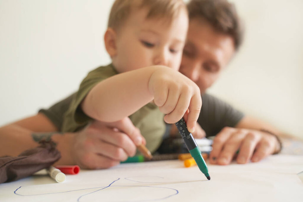 Young father helps son at age of two draw, teaches - Fotoğraf, Görsel