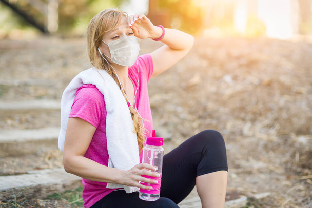 Orvosi maszkot viselő lány edzés közben a szabadban. - Fotó, kép