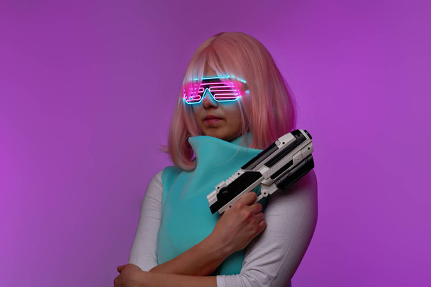 Girl with blaster in the futuristic battle. Concept virtual reality, cyber game. - Foto, immagini