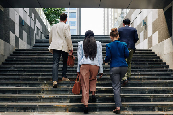 Ділові люди піднімаються по сходах, коли йдуть на роботу вранці
 - Фото, зображення