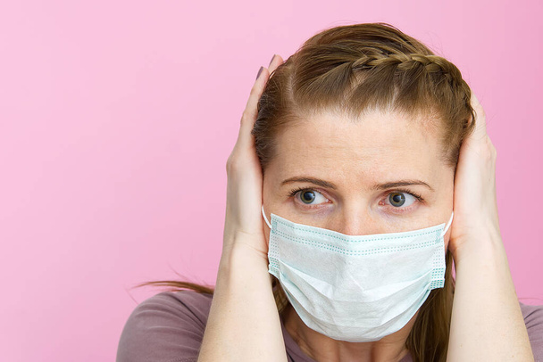 женщина в медицинской маске, затыкающая уши руками, не хочет слушать о вирусе. Европейская молодая женщина игнорирует шум или новости о коронавирусе. Концепция без новостей
 - Фото, изображение